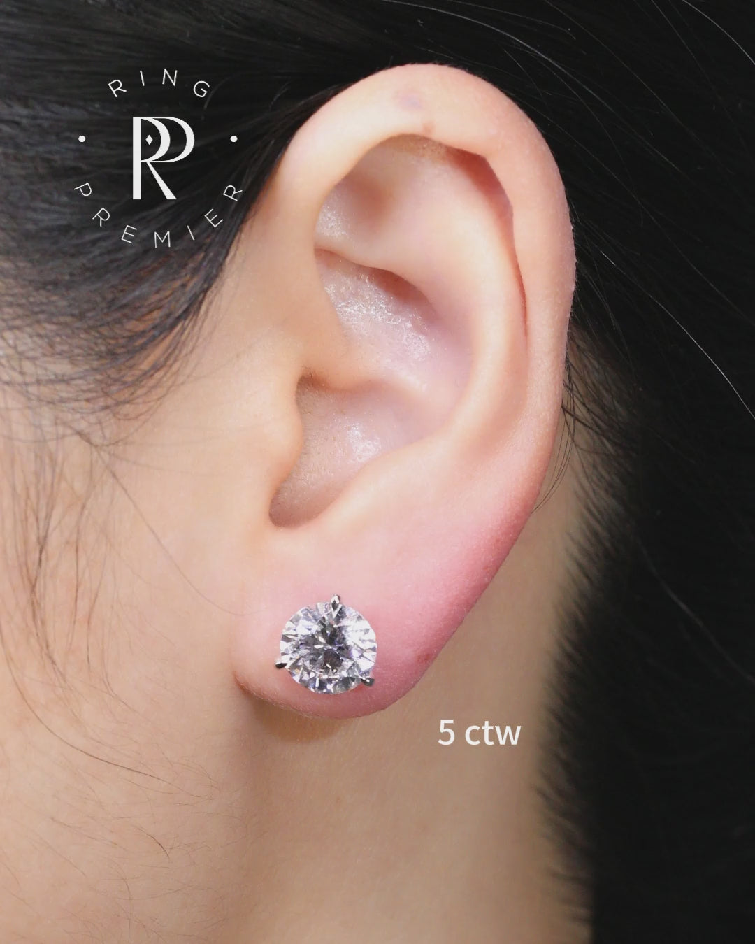 Florence 5 carat (5 ct tw) round lab-grown diamond stud earring in a 3-prong martini setting, worn on the ear to show real size