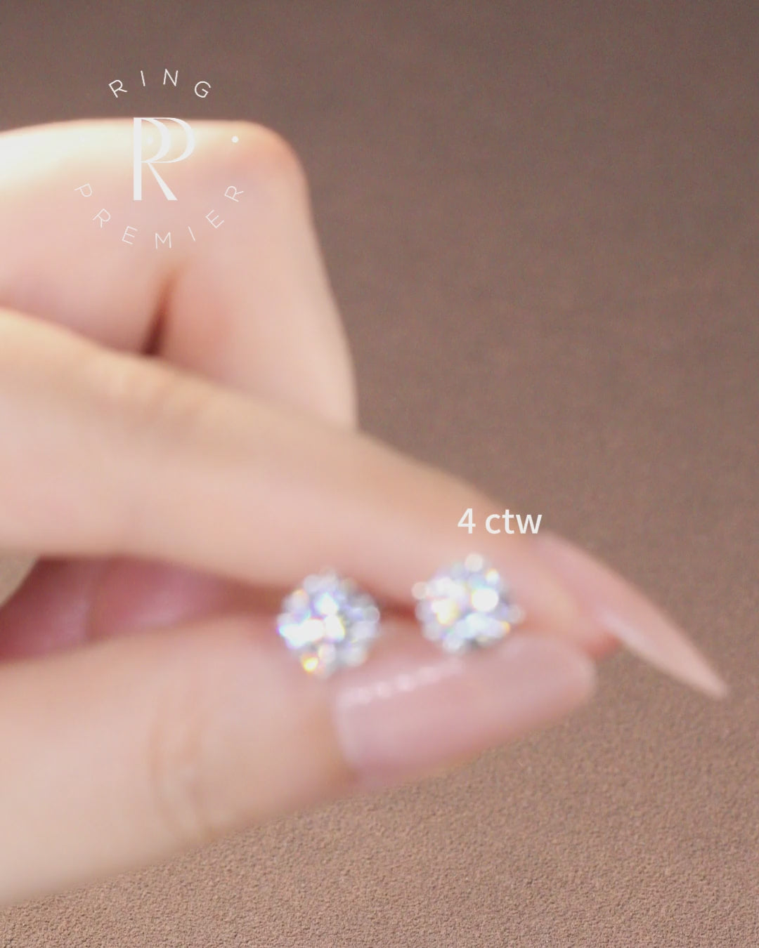 Geneva 4 carat (4 ct tw) round lab-grown diamond stud earrings in a 4-prong basket setting, shown held in hand