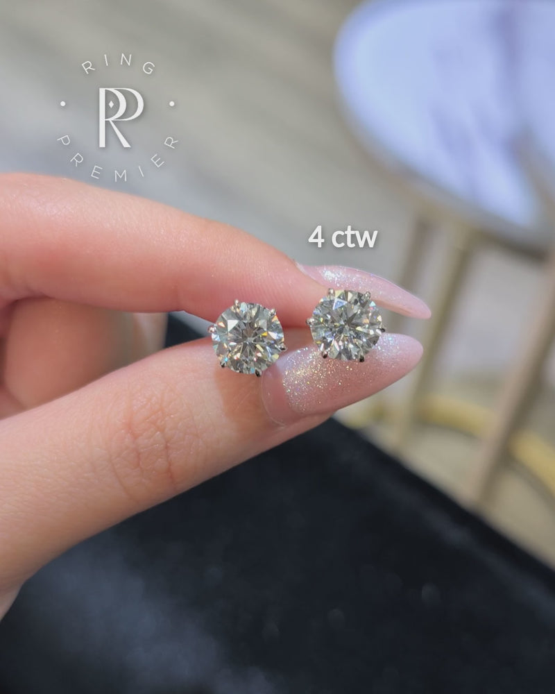 Vienna 4 carat (4 ct tw) round lab-grown diamond stud earrings in a white gold 6-prong crown setting, shown held in hand