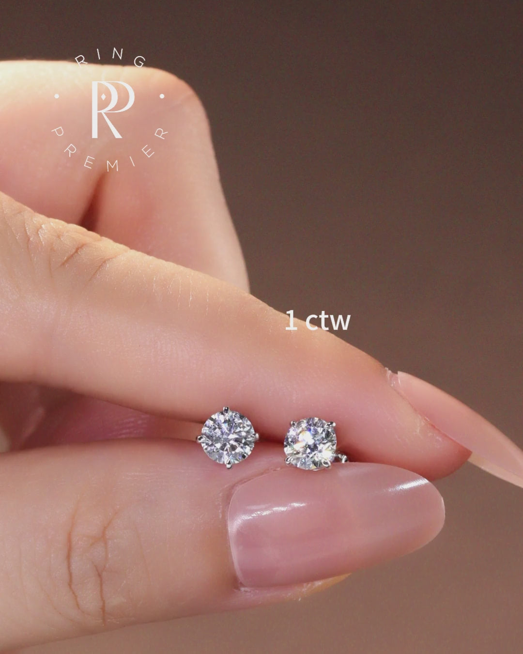 Geneva 1 carat (1 ct tw) round lab-grown diamond stud earrings in a 4-prong basket setting, shown held in hand