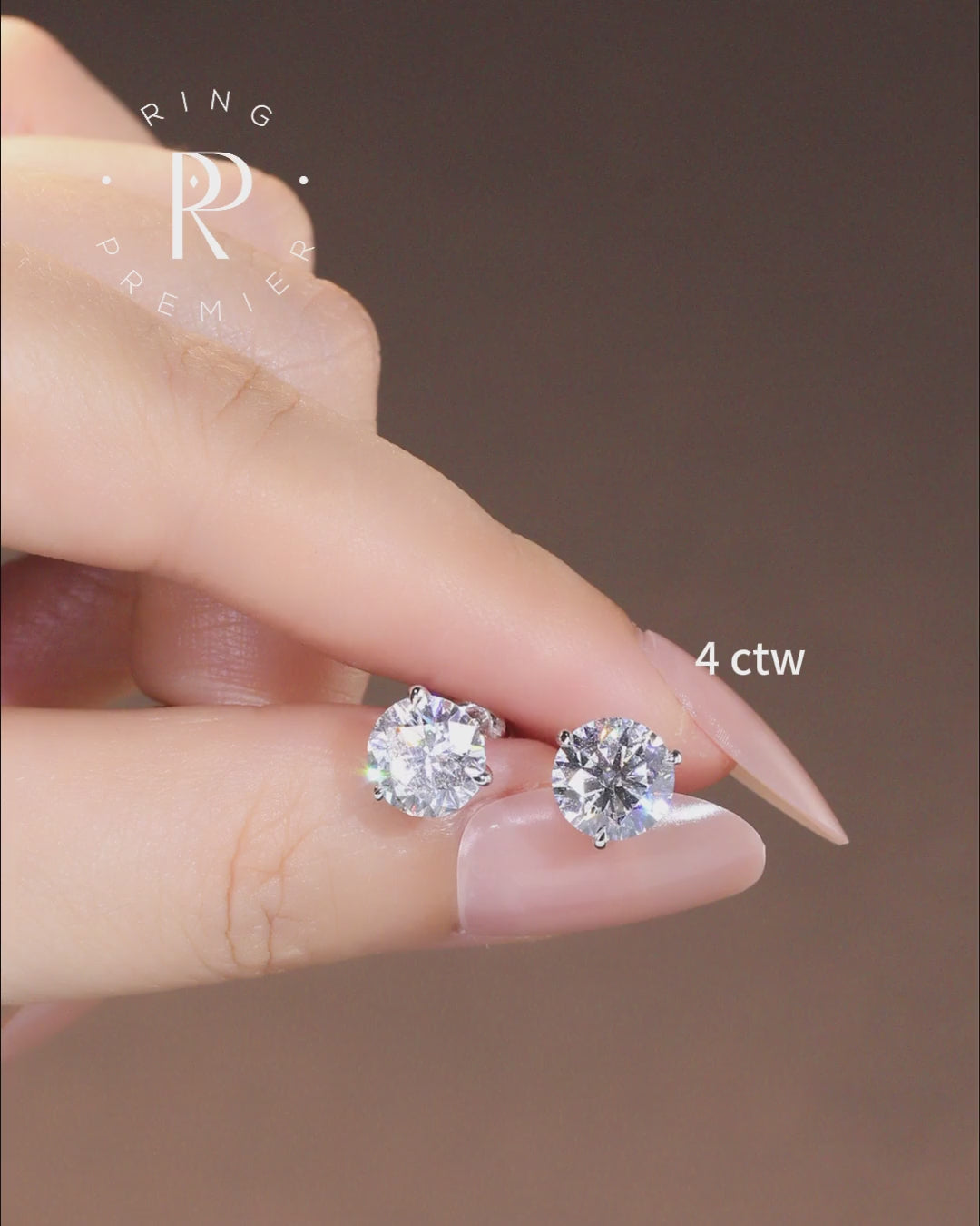 Florence 4 carat (4 ct tw) round lab-grown diamond stud earrings in a 3-prong martini setting, shown held in hand