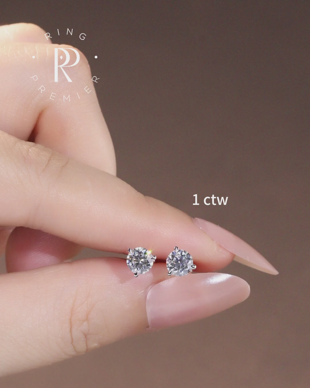 Florence 1 carat (1 ct tw) round lab-grown diamond stud earrings in a 3-prong martini setting, shown held in hand