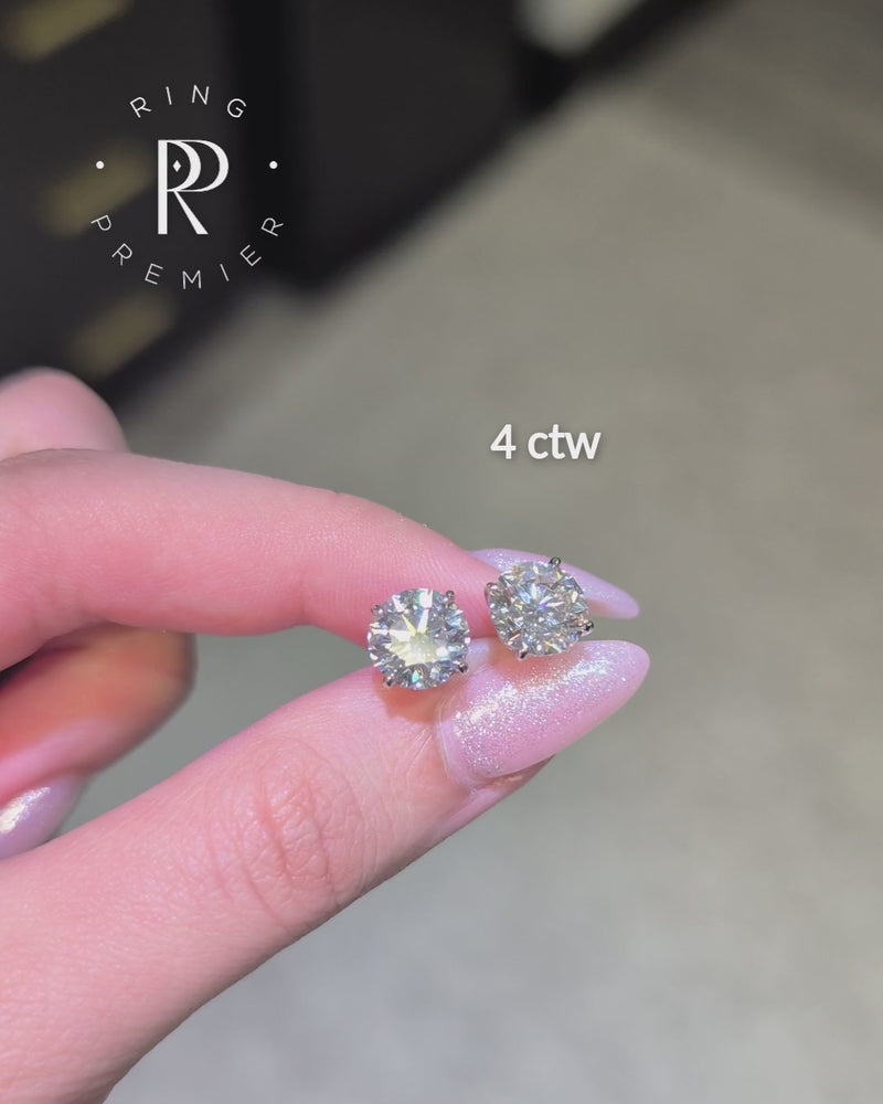 Geneva 4 carat (4 ct tw) round lab-grown diamond stud earrings in a white gold 4-prong basket setting, shown held in hand