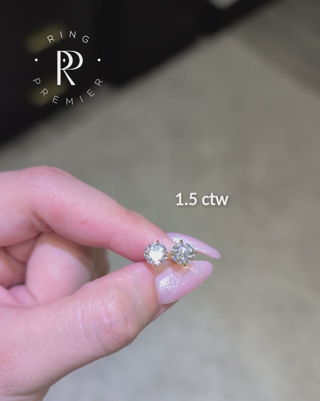 Geneva 1.5 carat (1.5 ct tw) round lab-grown diamond stud earrings in a yellow gold 4-prong basket setting, shown held in hand