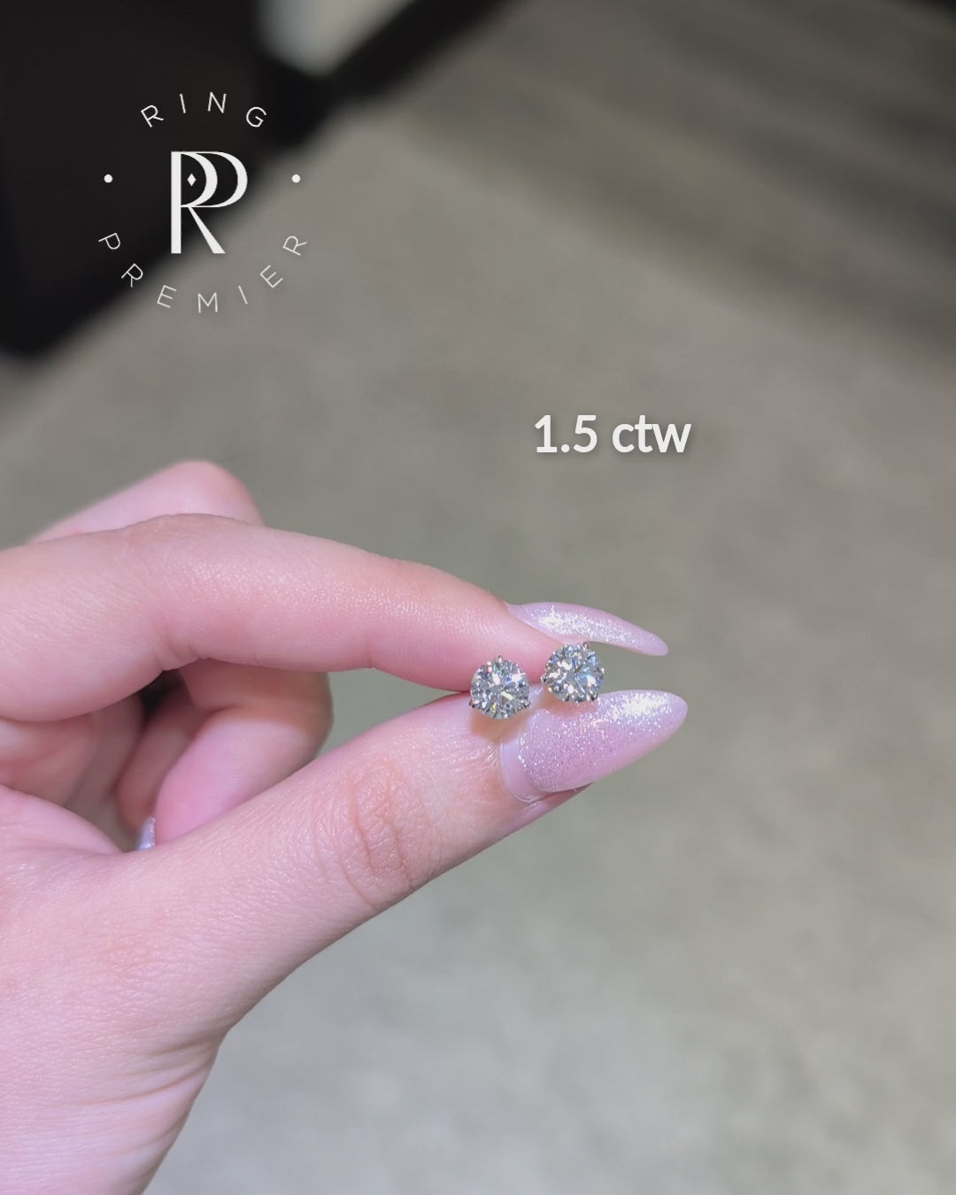 Florence 1.5 carat (1.5 ct tw) round lab-grown diamond stud earrings in a white gold 3-prong martini setting, shown held in hand