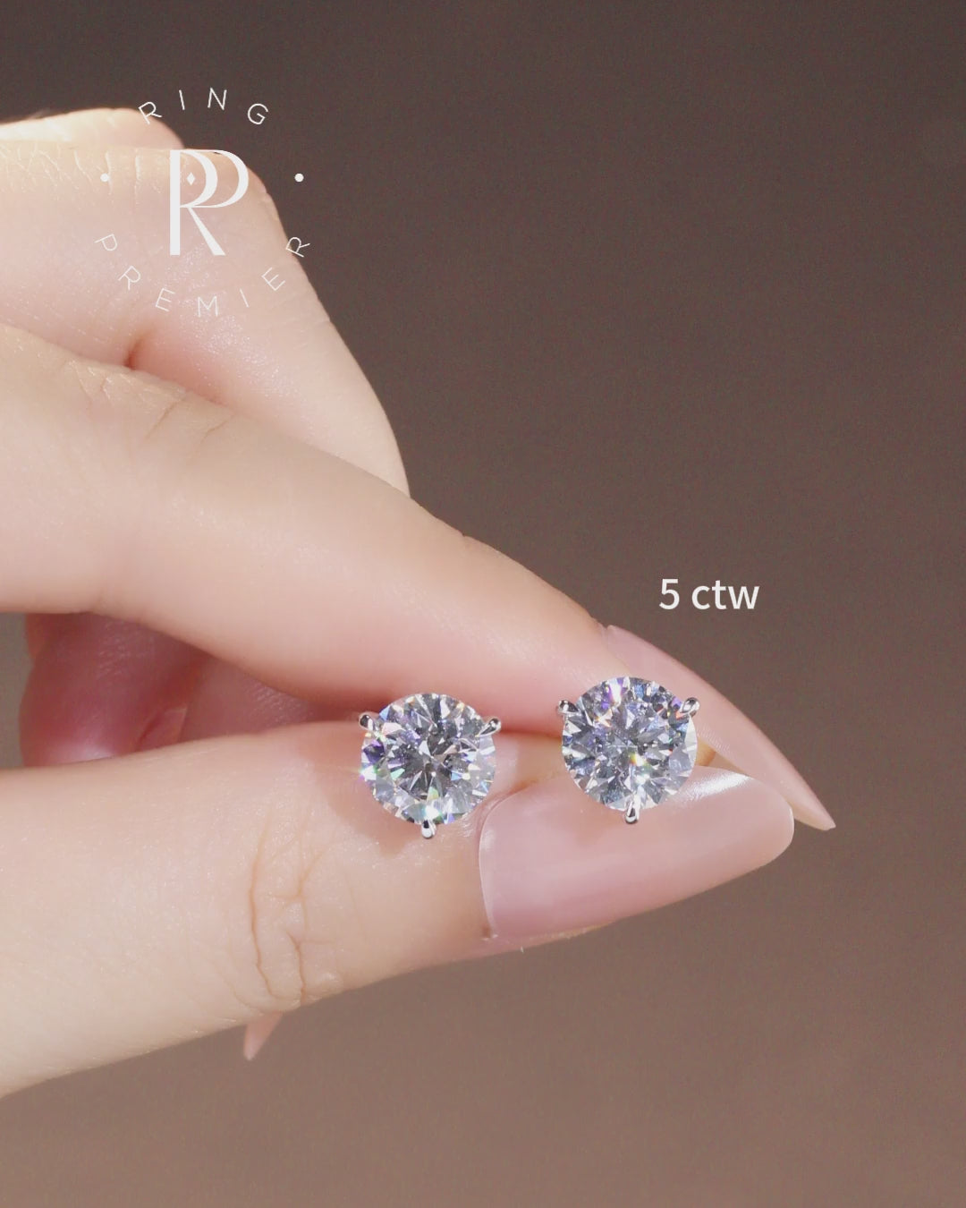 Florence 5 carat (5 ct tw) round lab-grown diamond stud earrings in a 3-prong martini setting, shown held in hand