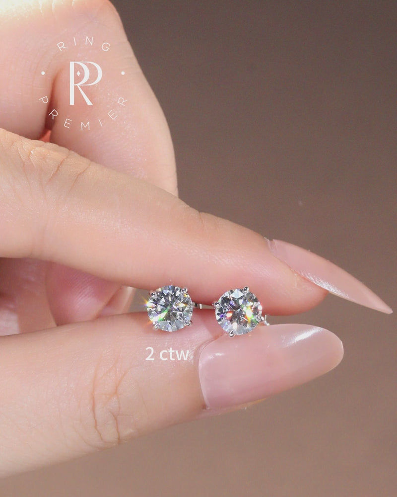 Geneva 2 carat (2 ct tw) round lab-grown diamond stud earrings in a 4-prong basket setting, shown held in hand