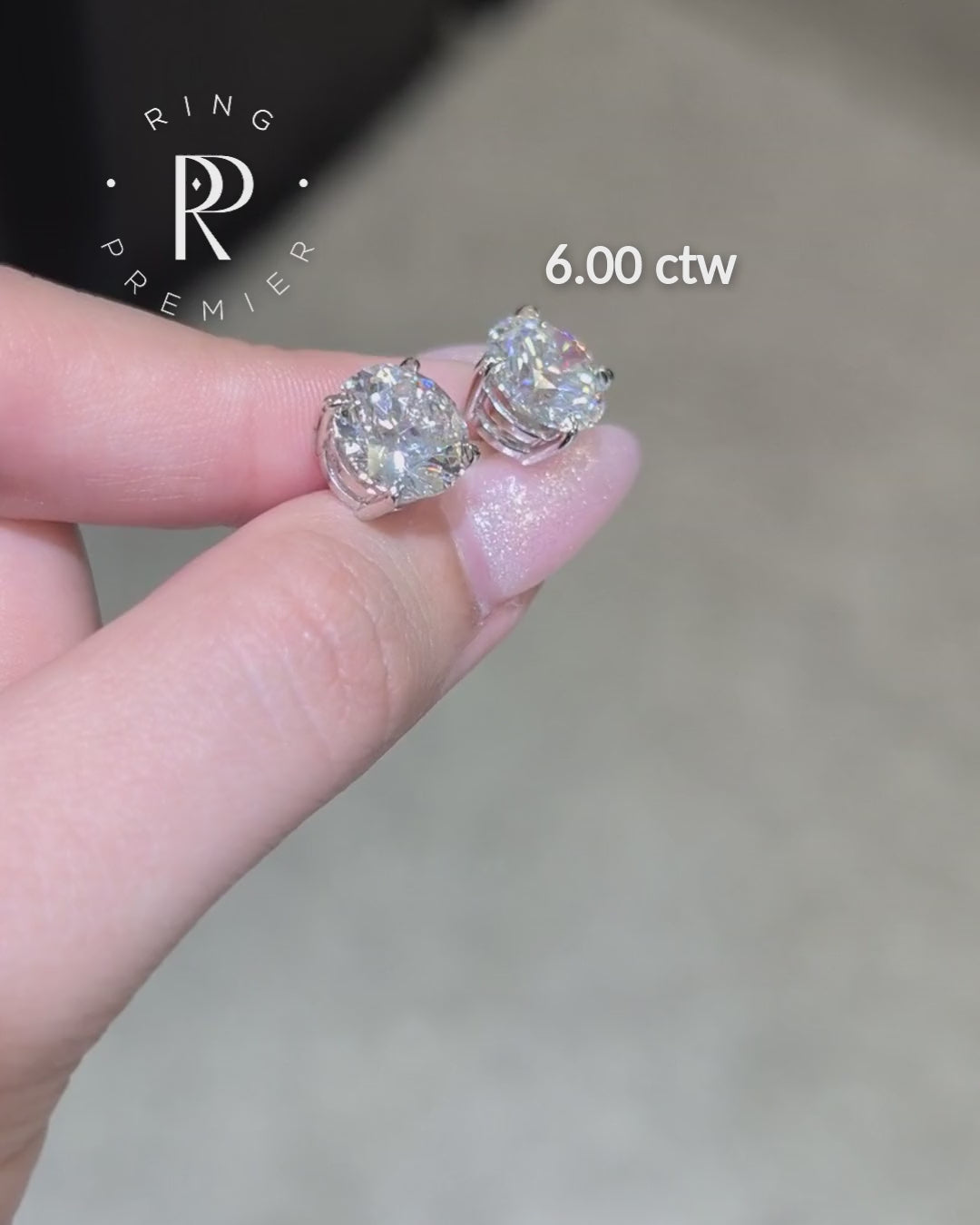 Geneva 4-prong basket round lab-grown diamond stud earrings, 6 ct tw pair in white gold shown held in hand