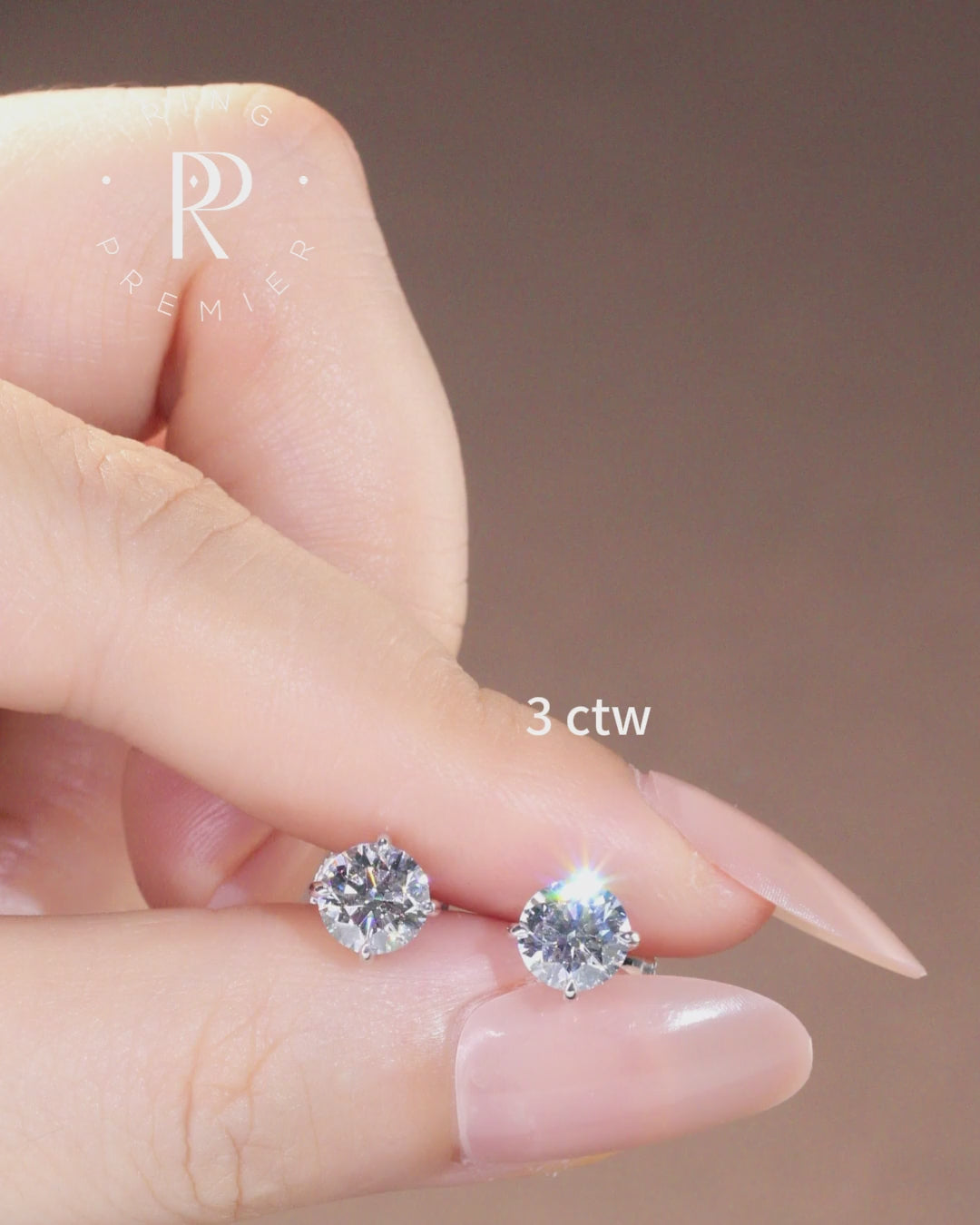 Geneva 3 carat (3 ct tw) round lab-grown diamond stud earrings in a 4-prong basket setting, shown held in hand