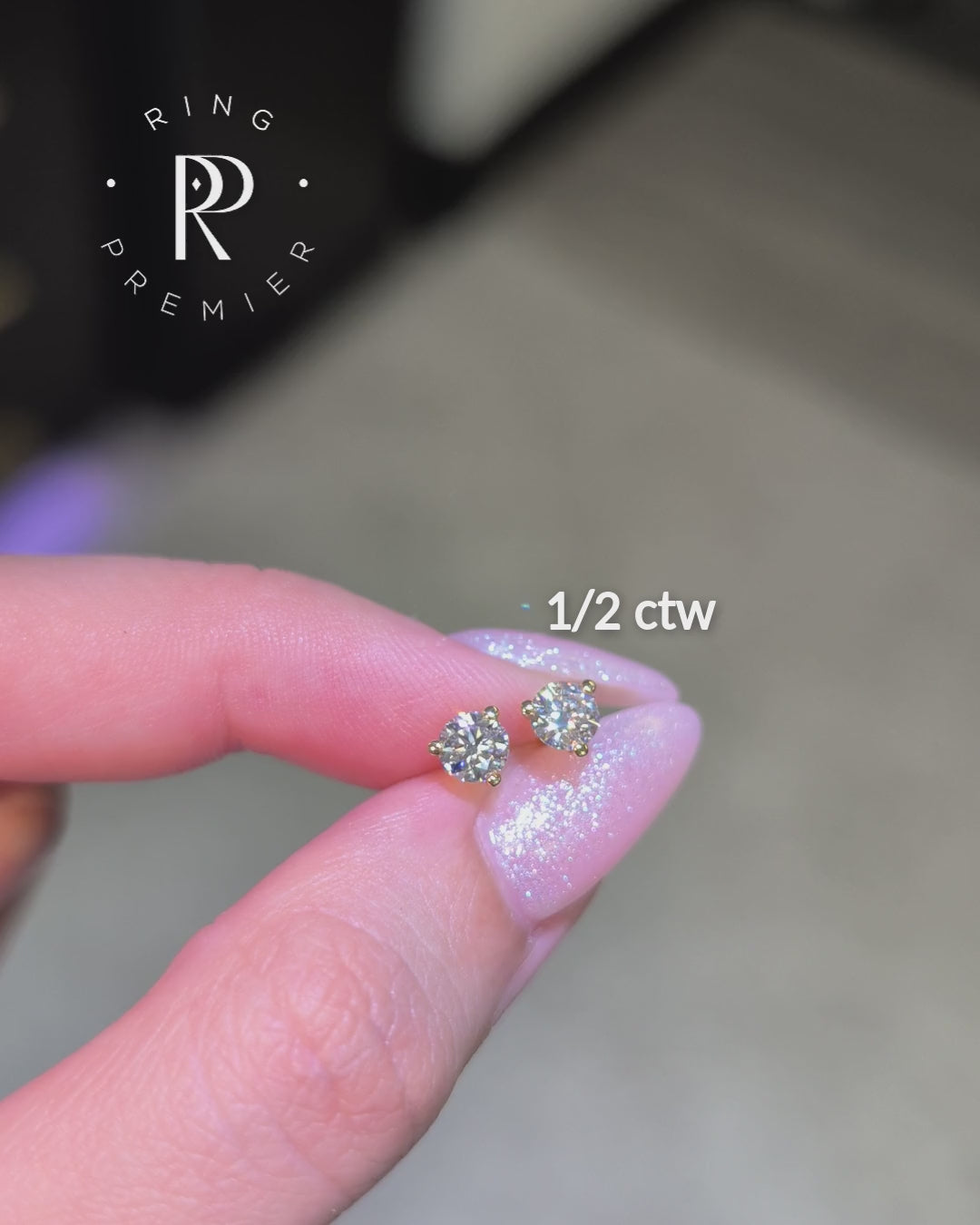 Florence 1/2 carat (1/2 ct tw) round lab-grown diamond stud earrings in a yellow gold 3-prong martini setting, shown held in hand